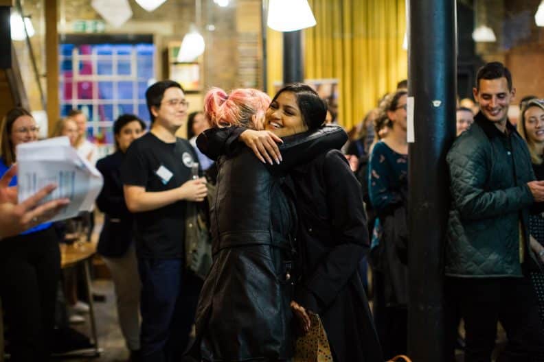 A photo of two female alumni hugging at our awards event