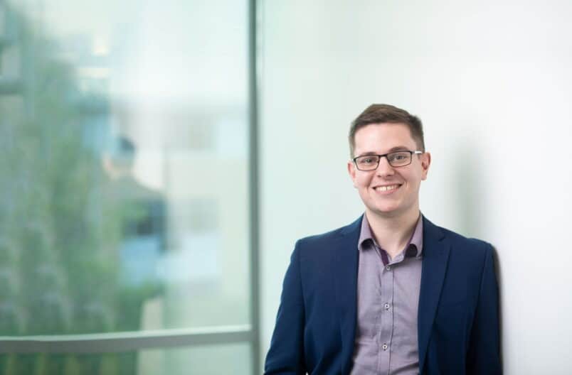 Professional photo of alum Matthew Cordwent leaning against a wall.